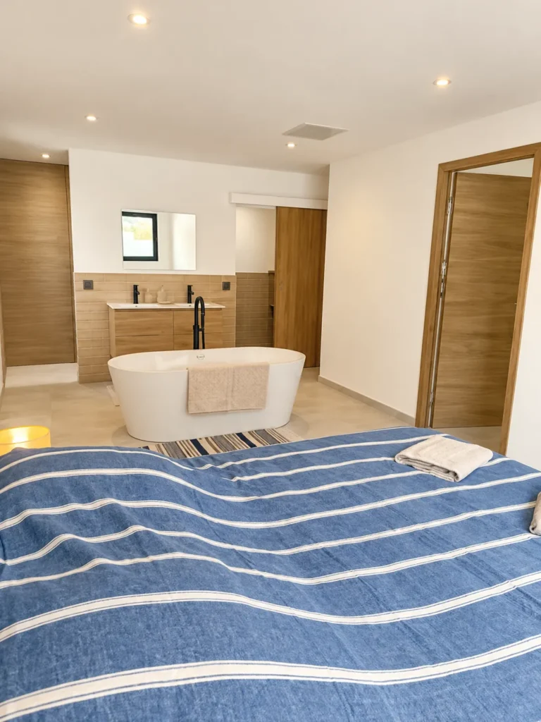 Vue de la chambre sur la baignoire îlot et l’espace bain – L’Annexe du Domaine de la Subérine
